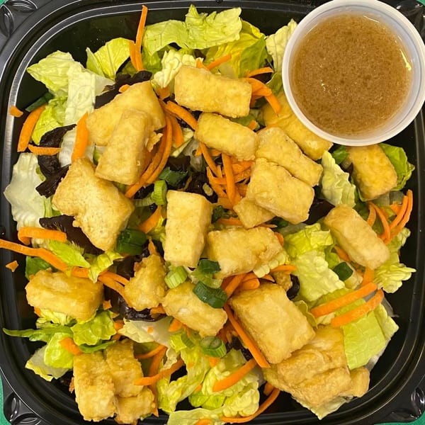 Maui Teriyaki and Sushi's fried tofu salad with lettuce, carrots, and a side of dressing.